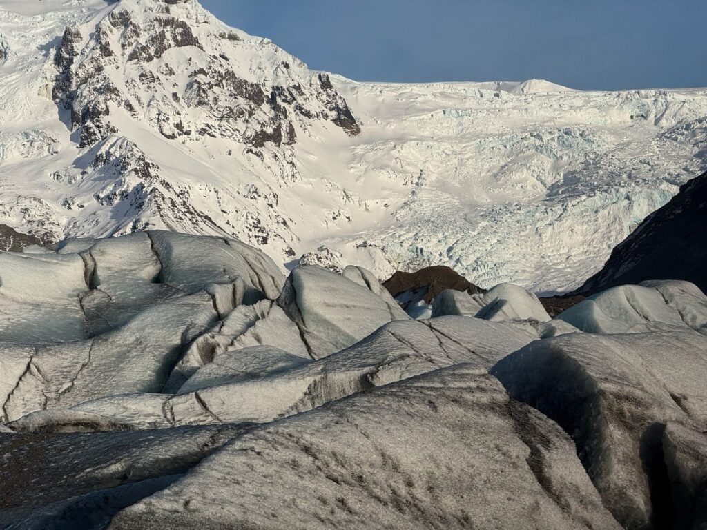 Glaciar nevado bajo una montaña blanca y cielo azul