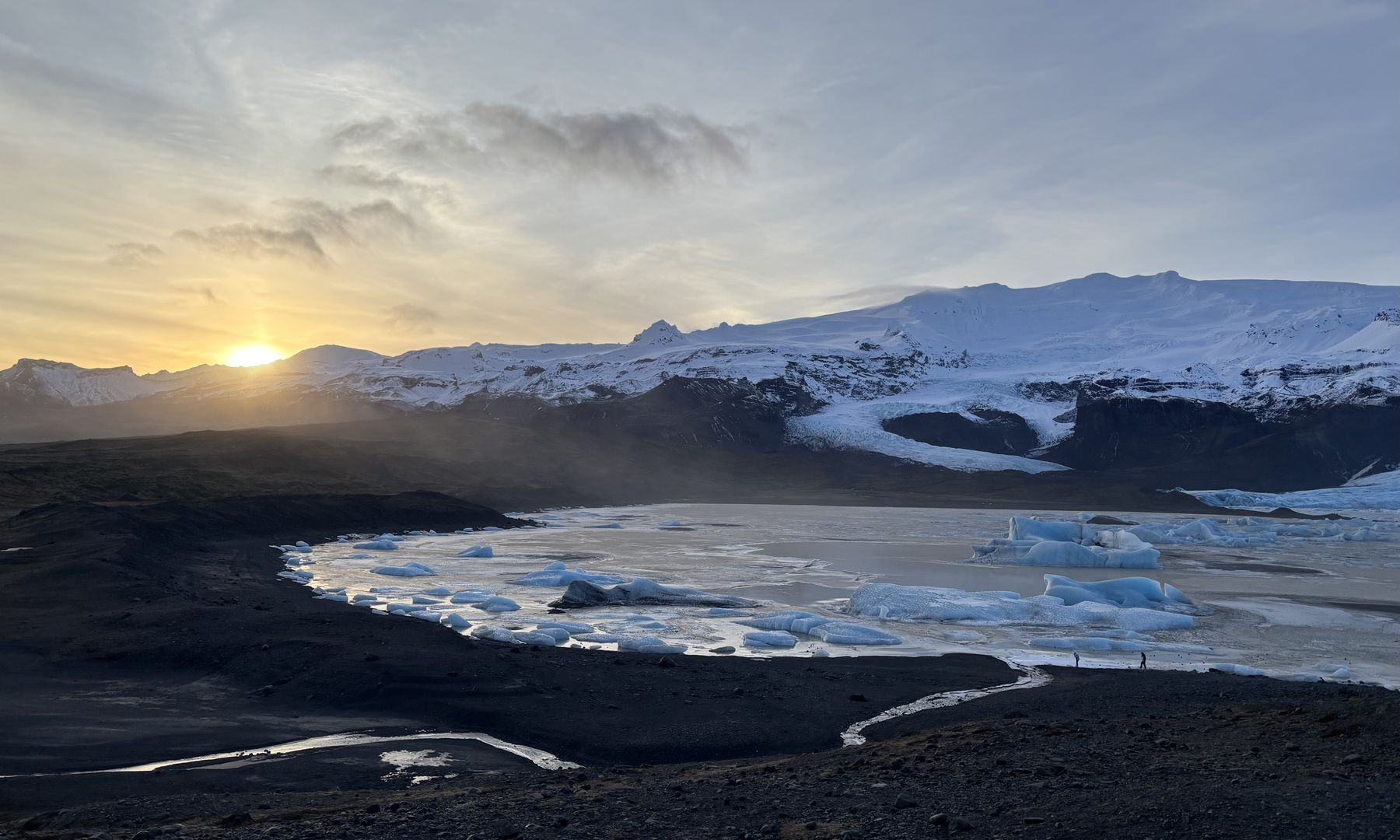 La laguna glaciar de Jökulsárlón al atardecer, con icebergs y montañas nevadas