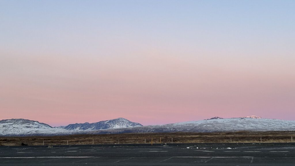 Llanura nevada bajo un cielo rosa de invierno