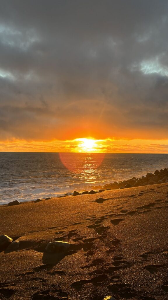 Atardecer naranja sobre la arena negra de Reynisfjara