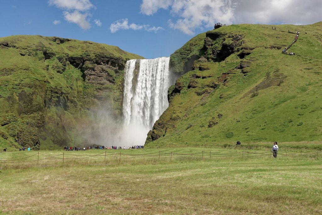 La ancha cascada de Skógafoss con un arcoíris en la neblina